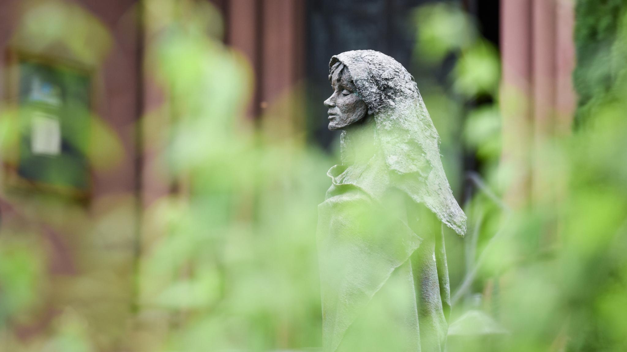 Eine Figur von Hildegard von Bingen steht im Klostergarten der Benediktinerinnenabtei Sankt Hildegard in Rüdesheim.
